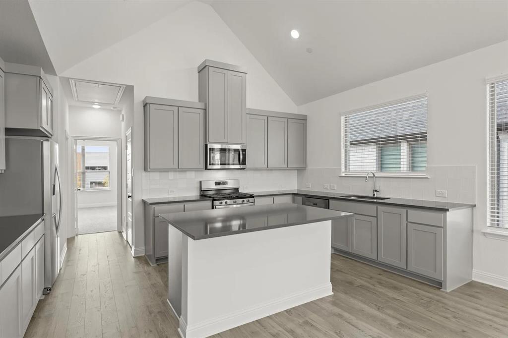 2543 Brunswick Way Allen, TX 75013 - Photo 9 of 38 a kitchen with stainless steel appliances granite countertop a sink stove and refrigerator