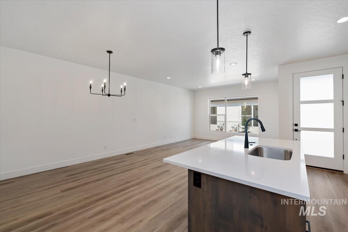 768 South Calhoun Lane Star, ID 83669 - Photo 9 of 36 Kitchen island featuring a stainless steel sink, matte black faucet, and white countertop
