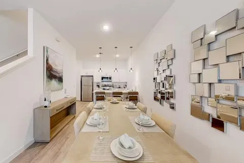 a large white kitchen with stainless steel appliances