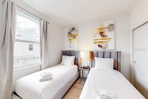 a bedroom with a bed and painting on the wall