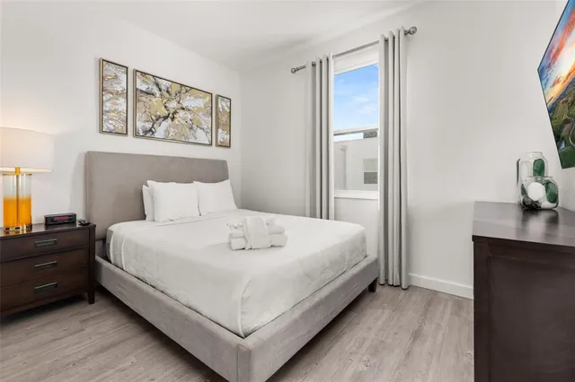 a spacious bedroom with two beds and painting on the wall