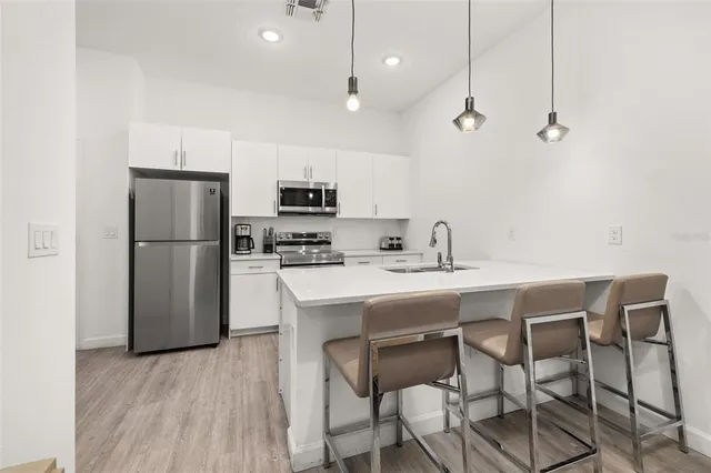 a kitchen with white cabinets stainless steel appliances and sink
