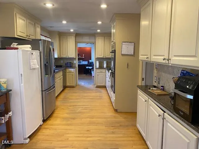 a kitchen with refrigerator a microwave and wooden floor