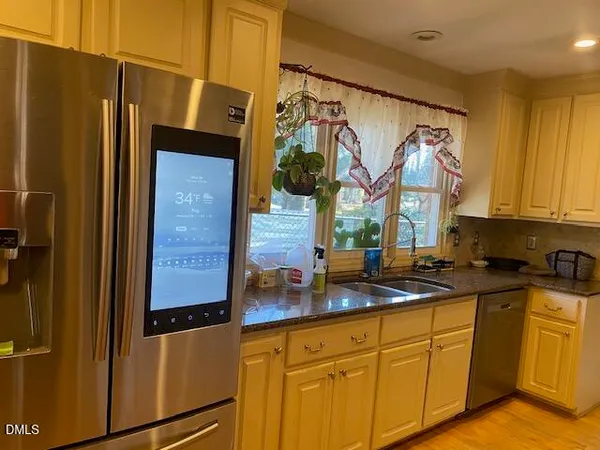 a kitchen with stainless steel appliances granite countertop a refrigerator and a sink