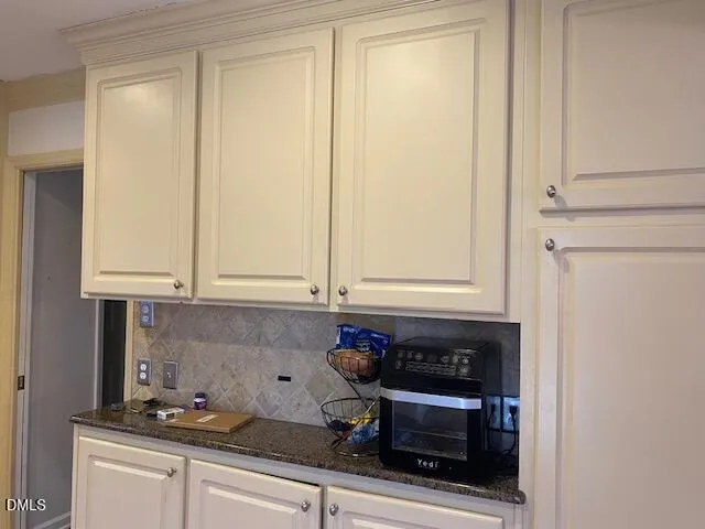 a kitchen with granite countertop white cabinets and stainless steel appliances