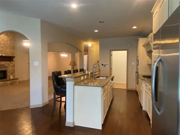a kitchen with kitchen island a sink stove and wooden floor