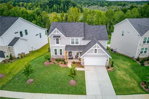 a aerial view of a house next to a big yard with large trees