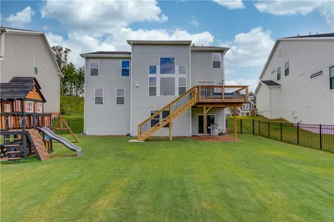 a view of a house with deck and a yard