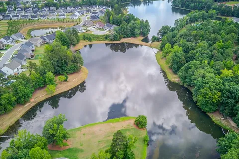 an aerial view of a house with a garden and lake view