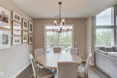 a view of a dining room with furniture large windows and wooden floor