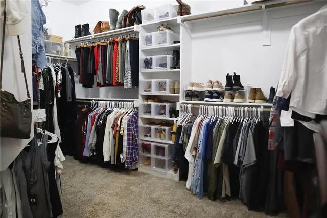 a view of walk in closet with clothes and shoes