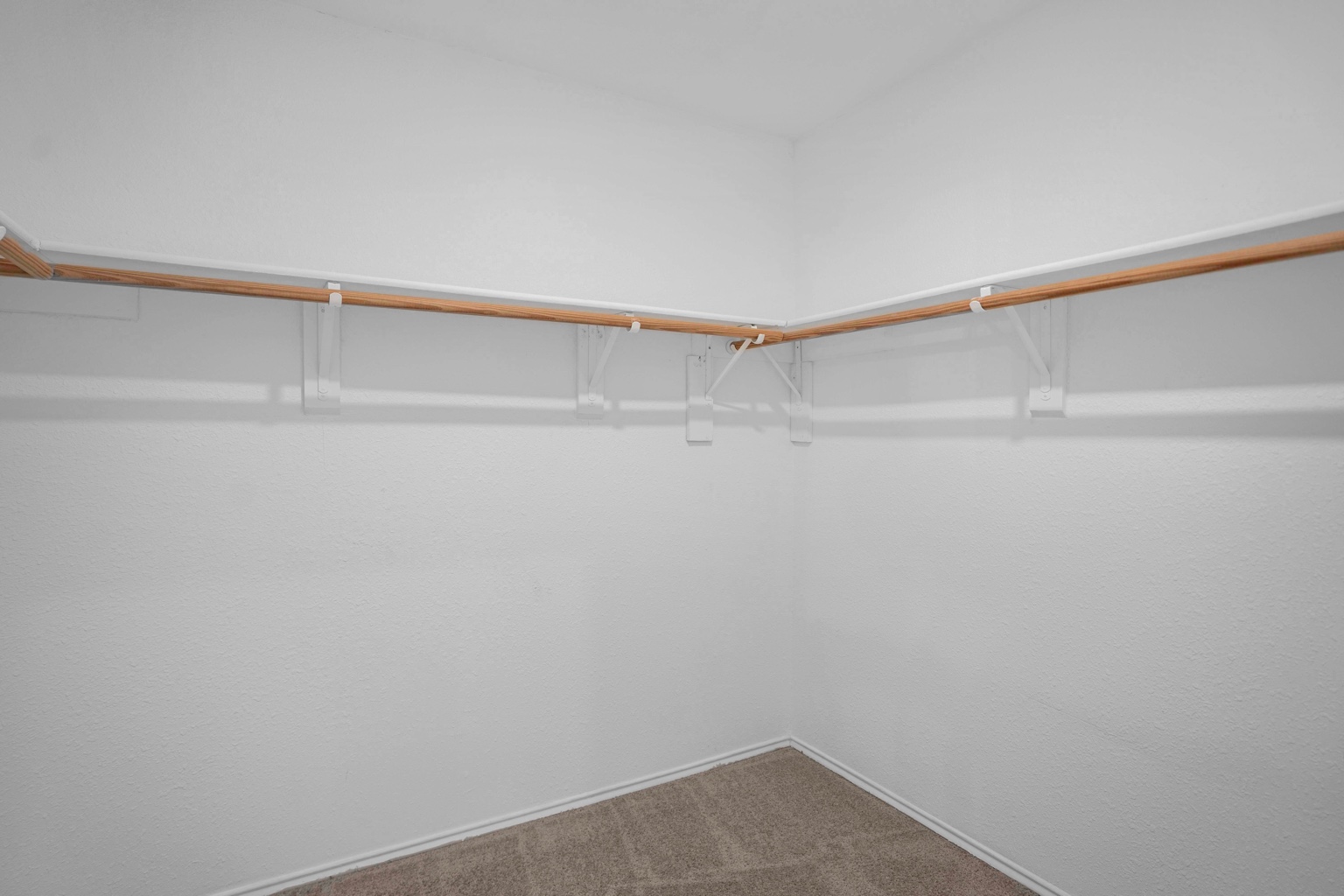 800 Smoke Signal Pass Pflugerville, TX 78660 - Photo 15 of 40 A spacious walk-in closet with ample hanging space and neutral carpeting.
