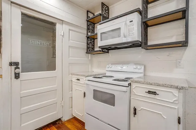 a kitchen with stainless steel appliances granite countertop white cabinets and white appliances