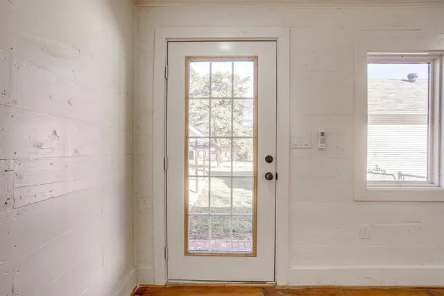 an empty room with wooden floor fan and windows