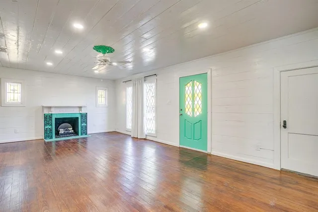 an empty room with wooden floor and fireplace