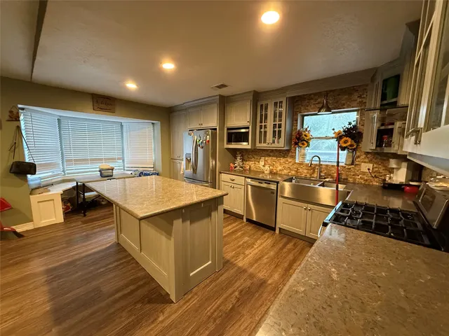 a kitchen with stainless steel appliances a stove a sink and a refrigerator