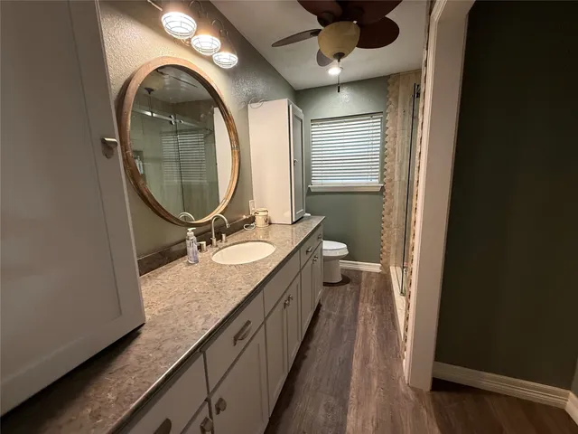 a bathroom with a granite countertop double vanity sink and a mirror