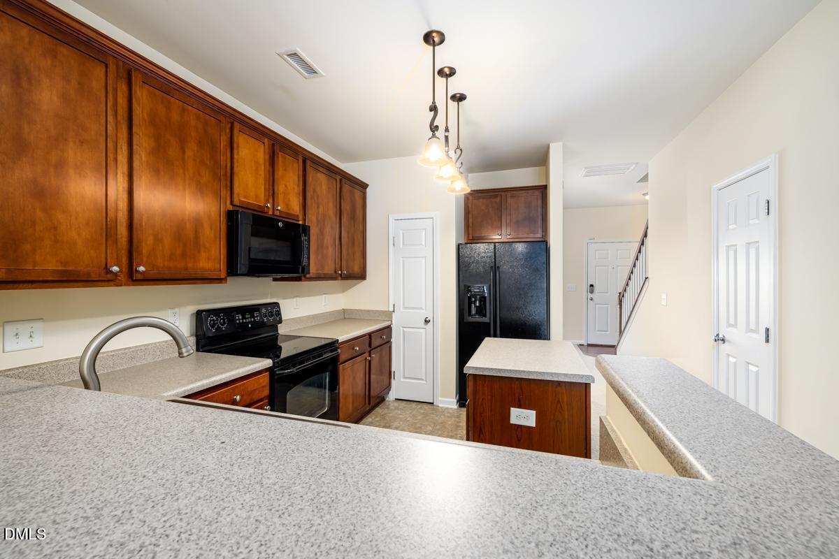 1619 Snow Mass Way Durham, NC 27713 - Photo 5 of 16 a kitchen with stainless steel appliances granite countertop a sink refrigerator stove and microwave
