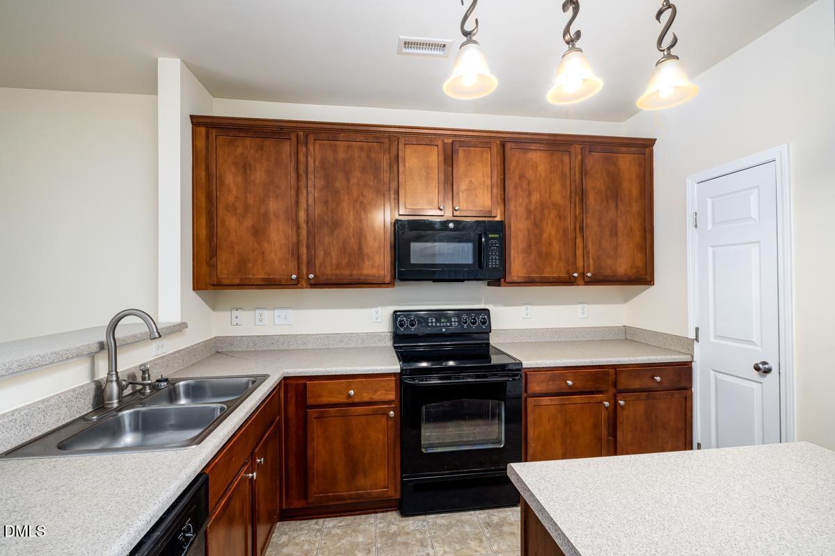 1619 Snow Mass Way Durham, NC 27713 - Photo 6 of 16 a kitchen with stainless steel appliances granite countertop a sink stove and microwave