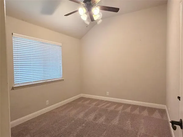an empty room with a window and a fan