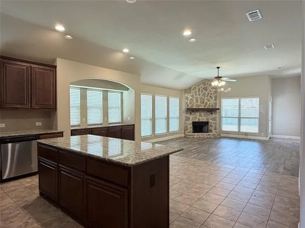 a large kitchen with granite countertop a sink and cabinets