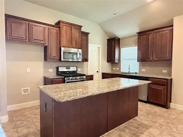 a kitchen with stainless steel appliances granite countertop a stove sink and cabinets
