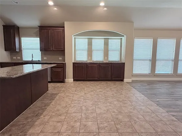 a large kitchen with granite countertop a stove a sink and a granite counter tops