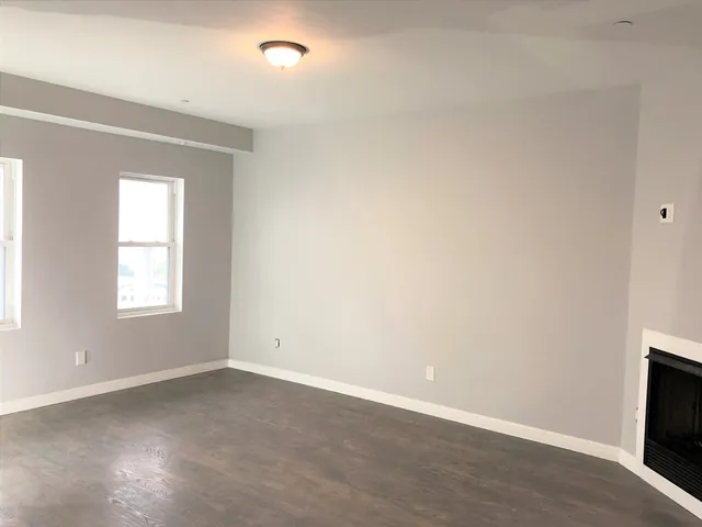 an empty room with a fireplace and a window