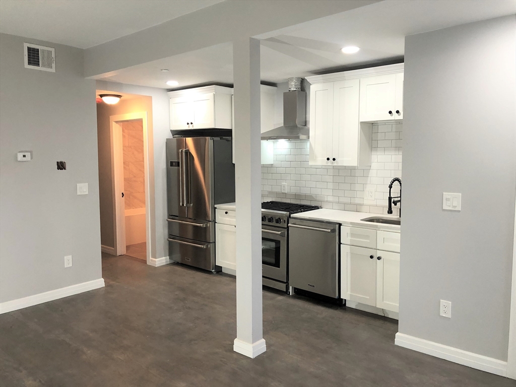 47-49 Walnut Street, Unit 1 Boston, MA 02122 - Photo 7 of 10 a kitchen with a refrigerator sink and cabinets