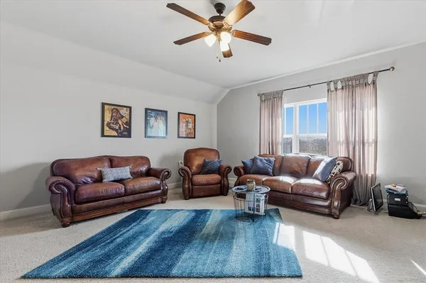 a living room with furniture ceiling fan and a window