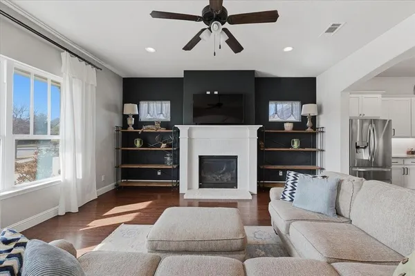 a living room with furniture a fireplace and a flat screen tv