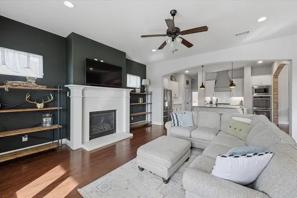 a living room with furniture a flat screen tv and a fireplace
