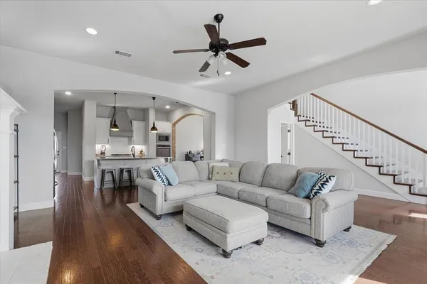 a living room with furniture and a wooden floor