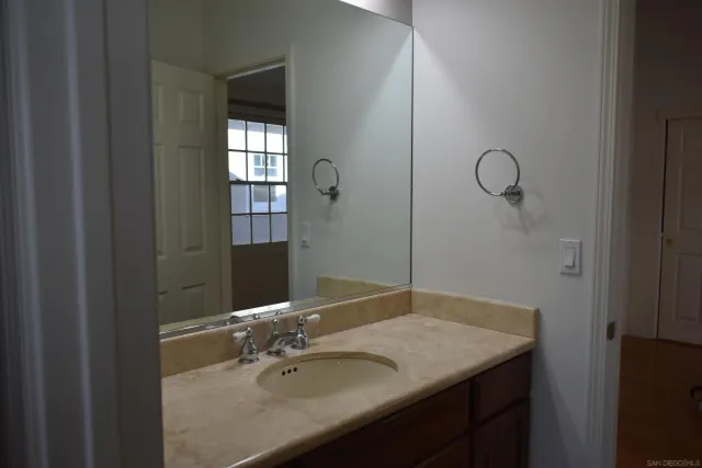 a bathroom with a granite countertop sink and a mirror