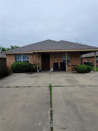 a front view of a house with a yard and potted plants