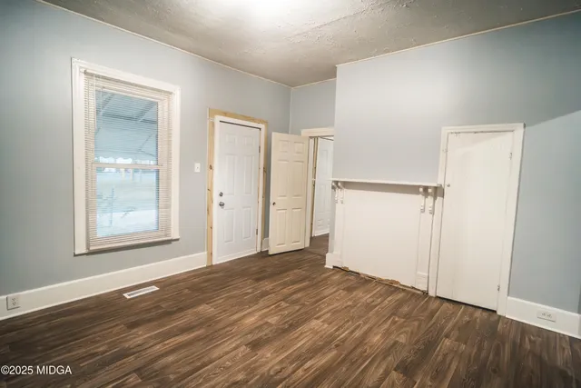 an empty room with wooden floor and a window