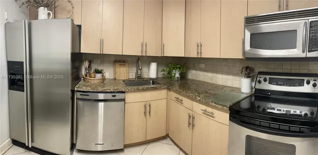 a kitchen with stainless steel appliances granite countertop a stove a refrigerator and a microwave