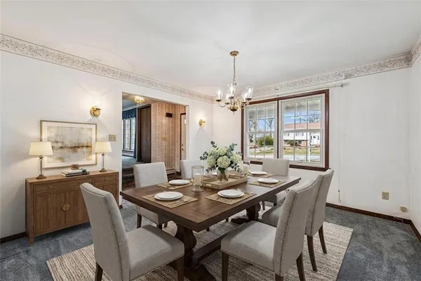 a view of an empty room with window and chandelier fan