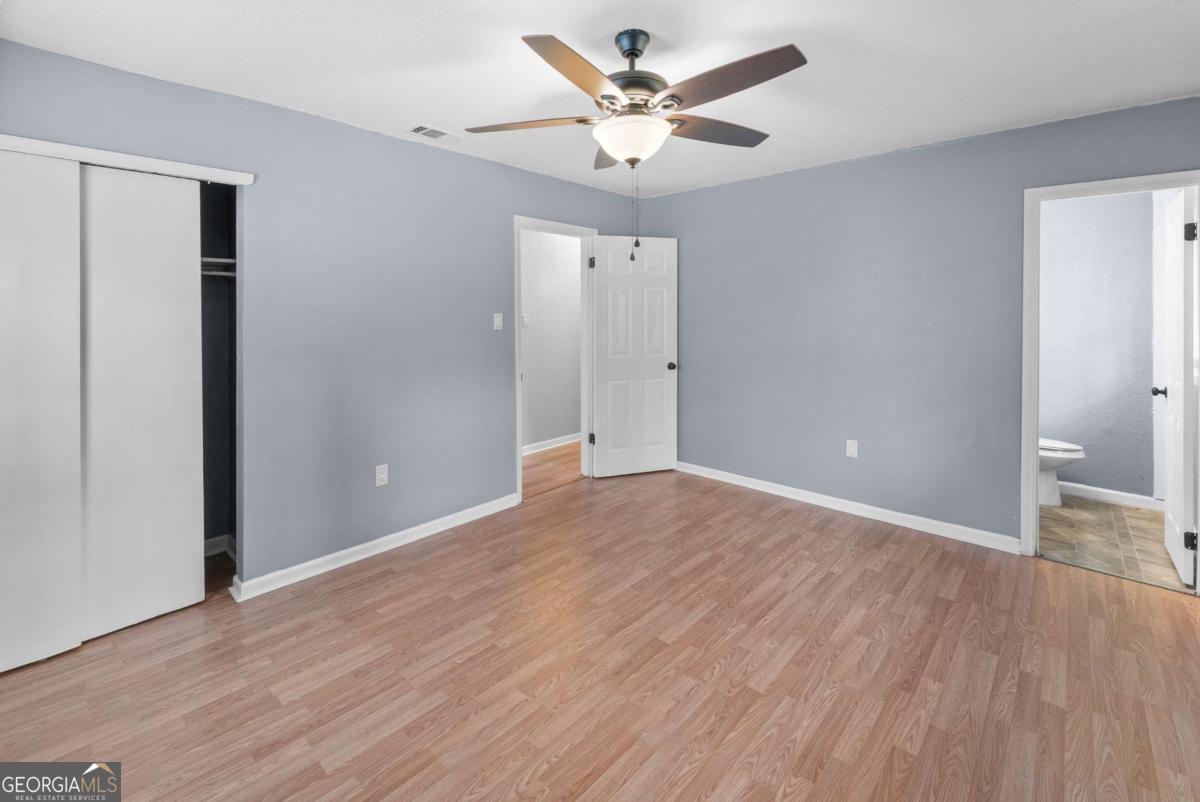 320 West Whatley Street Pooler, GA 31322 - Photo 18 of 34 an empty room with wooden floor and a ceiling fan