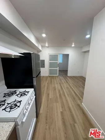 a view of an empty room with wooden floor and closet