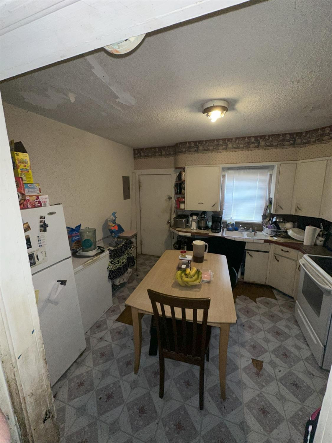 115 Yonkers Street Plainview, TX 79072 - Photo 13 of 20 a kitchen with a table chairs sink and stove