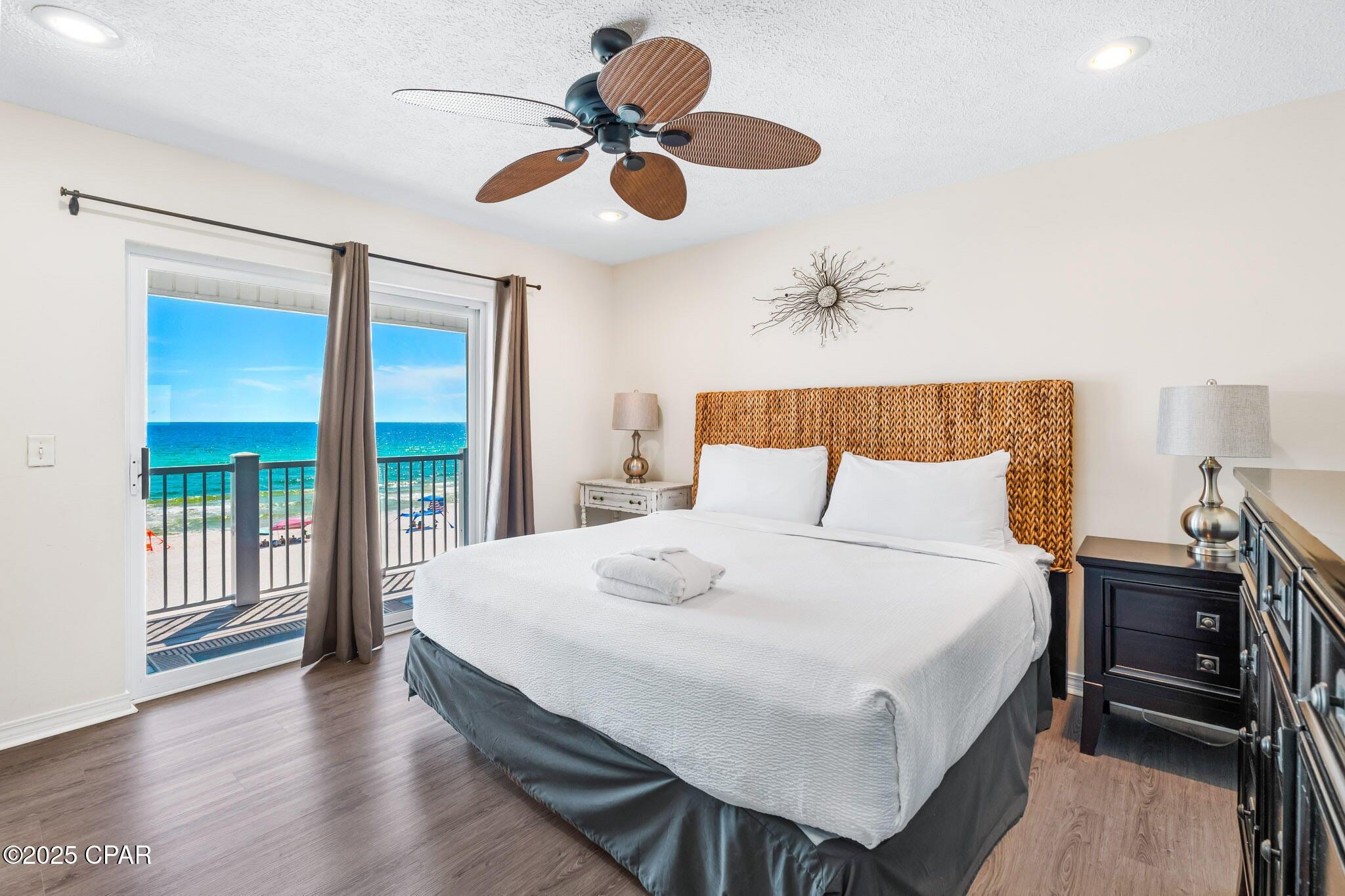 17657 Front Beach Road, Unit B Panama City Beach, FL 32413 - Photo 16 of 34 a bedroom with a bed and a chandelier