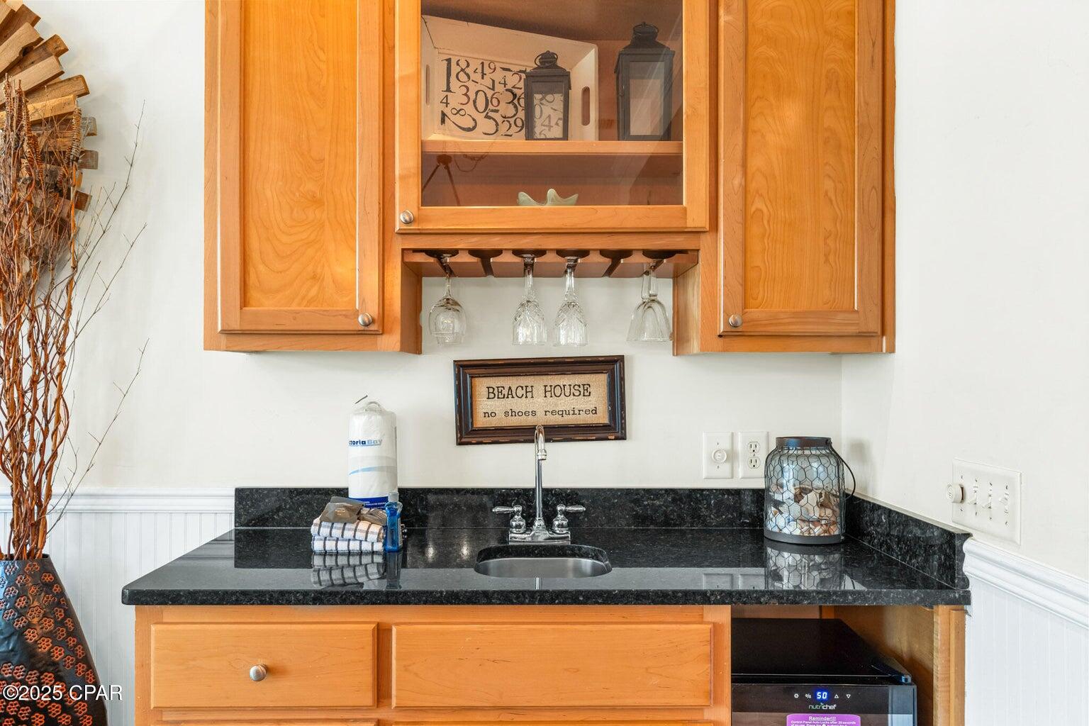 17657 Front Beach Road, Unit B Panama City Beach, FL 32413 - Photo 21 of 34 a kitchen with granite countertop white cabinets and black appliances