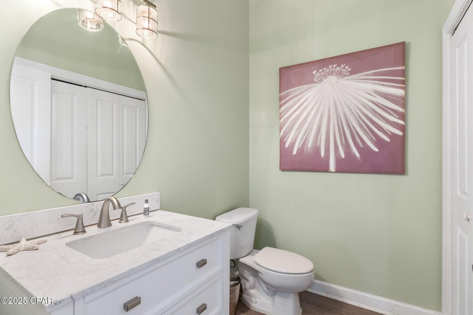 17657 Front Beach Road, Unit B Panama City Beach, FL 32413 - Photo 23 of 34 a bathroom with a sink vanity mirror and toilet