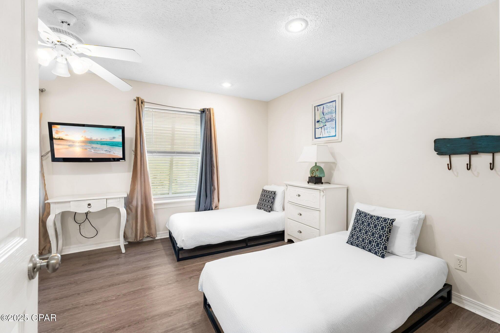17657 Front Beach Road, Unit B Panama City Beach, FL 32413 - Photo 25 of 34 a bedroom with two beds and a large mirror next to a window