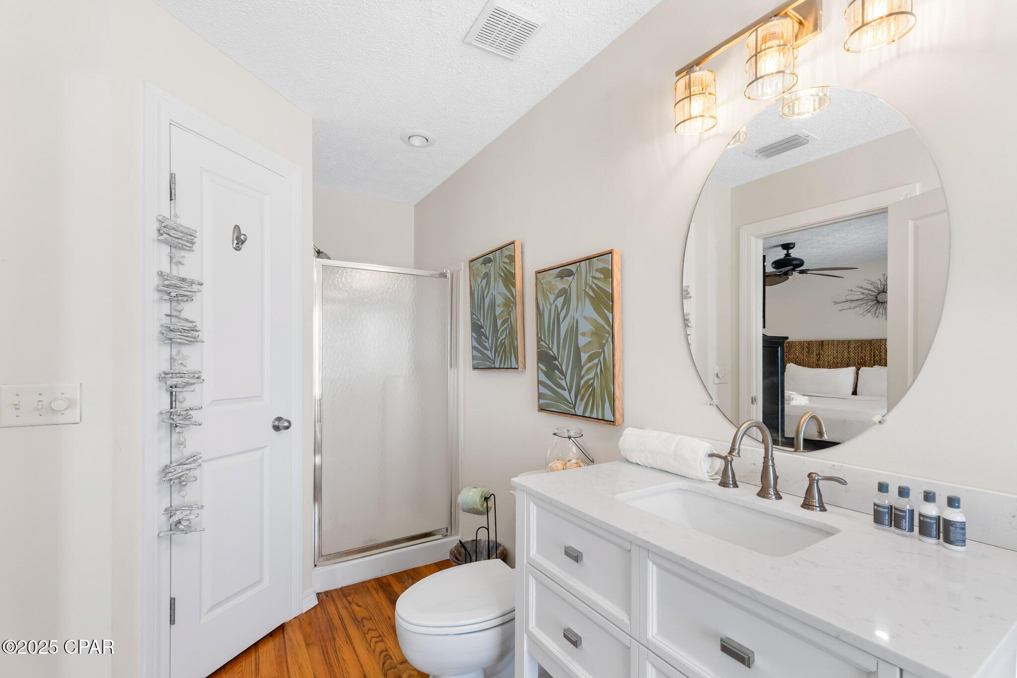 17657 Front Beach Road, Unit B Panama City Beach, FL 32413 - Photo 28 of 34 a bathroom with a sink a toilet and shower a mirror