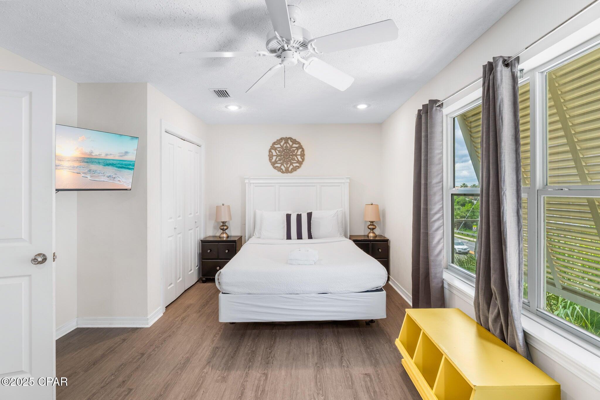 17657 Front Beach Road, Unit B Panama City Beach, FL 32413 - Photo 30 of 34 a bedroom with a bed and wooden floor