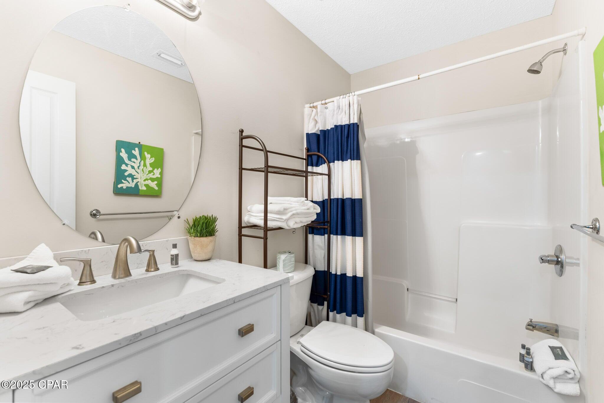 17657 Front Beach Road, Unit B Panama City Beach, FL 32413 - Photo 32 of 34 a bathroom with a sink a toilet and shower