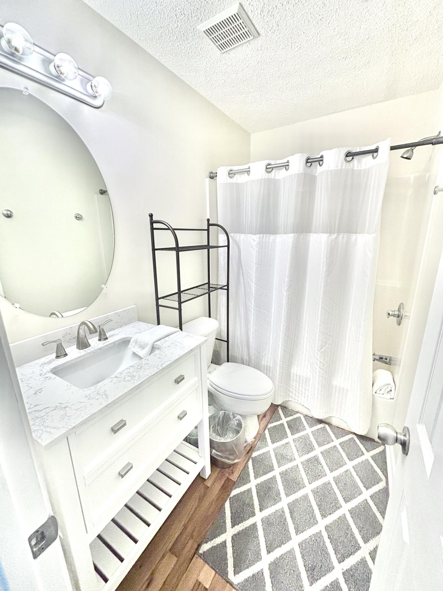 17657 Front Beach Road, Unit B Panama City Beach, FL 32413 - Photo 33 of 34 a bathroom with a sink mirror vanity and toilet