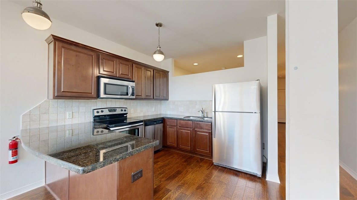 206 North Main Street, Unit 123 Bryan, TX 77803 - Photo 6 of 19 a kitchen with stainless steel appliances granite countertop a refrigerator sink stove microwave and cabinets